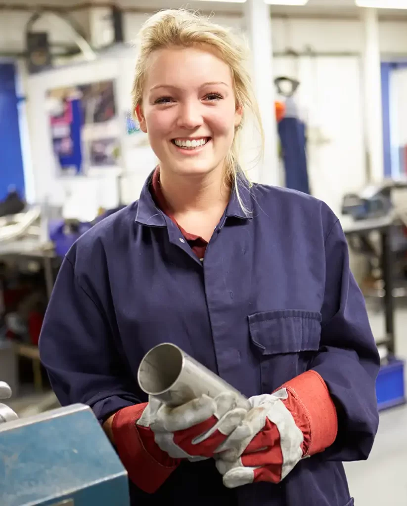 Female apprentice engineer working on a factory floor